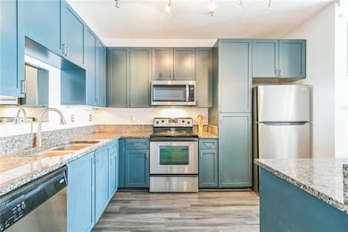Kitchen with light stone countertops, sink, a text