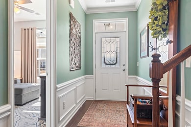 Entrance foyer with dark wood-style floors, stairw