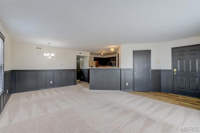 The living room view encompassing the front door (far right) dining area and kitchen.
