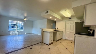 Kitchen featuring stove, white cabinets, sink, cei
