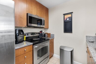 Kitchen with light tile floors, light stone counte