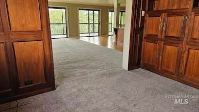 Corridor featuring dark colored carpet