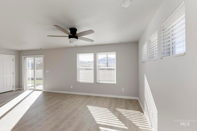 Spare room featuring healthy amount of natural light, light wood finished floors, and a ceiling fan