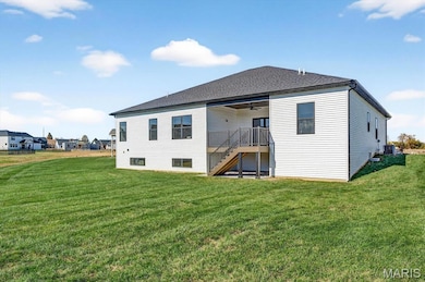 Rear view of property with stairway, a yard, a ceiling fan, and roof with shingles