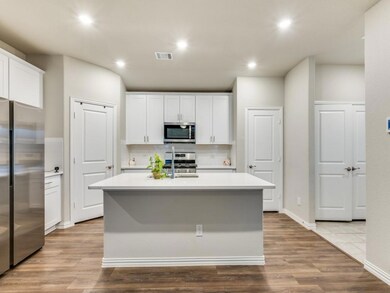 Kitchen featuring a center island with sink, white