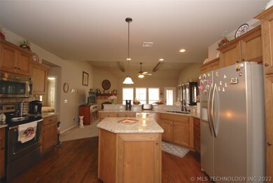Kitchen with hardwood flooring, an island, a pantr