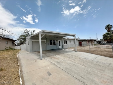 View of front facade with driveway, a carport, and