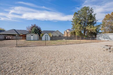 View of front of property with a storage unit, a fenced backyard, and a residential view