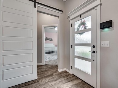 Doorway with a barn door and light wood-type floor