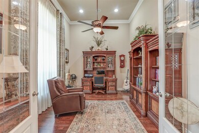 Executive study with tall ceiling, hardwood flooring, and crown molding.