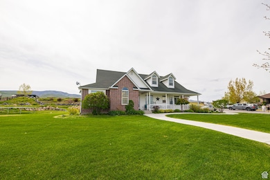 View of front facade with a porch, a front yard, and brick siding