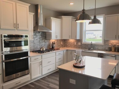 A chef's kitchen with soft close doors, drawers, and maintenance free vinyl plank floors. Colors may vary.