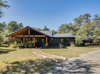 View of front facade with a front lawn, a metal roof, a standing seam roof, and board and batten siding
