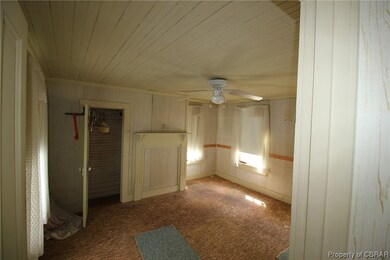 Carpeted empty room featuring ceiling fan and wood