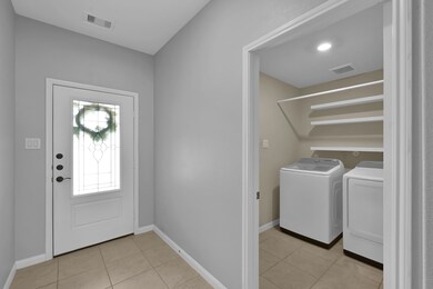 This photo shows a welcoming entryway with tiled f