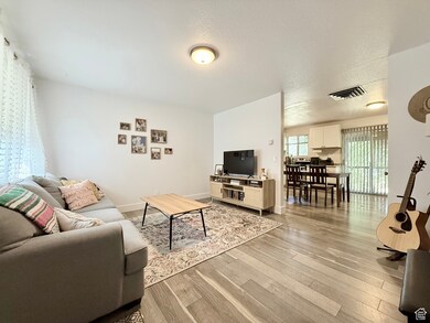 Living room featuring light wood-type flooring and a textured ceiling