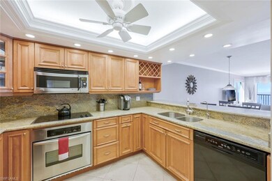 Kitchen featuring ornamental molding, a tray ceili