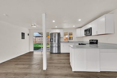 Kitchen featuring white cabinets, appliances with stainless steel finishes, light wood-style flooring, recessed lighting, and a peninsula