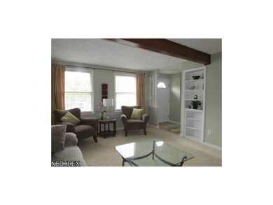 The living room features an exposed beam and built