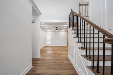 Staircase featuring recessed lighting, wood finished floors, baseboards, and ceiling fan