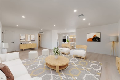 Living room featuring light wood finished floors and recessed lighting