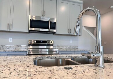 Kitchen featuring appliances with stainless steel finishes and light stone countertops