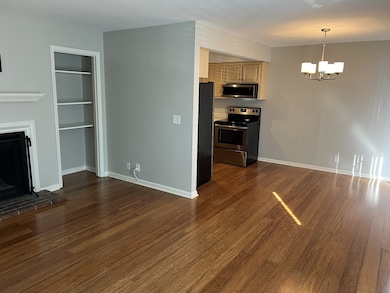 Layout is open with laminate hardwood flooring in main living areas. Dining area is to the right of the Kitchen.