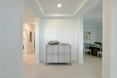Corridor with recessed lighting, a raised ceiling, and light tile patterned floors