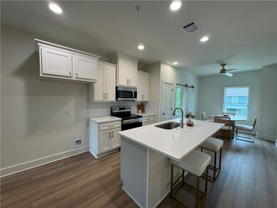 Kitchen with white cabinetry, dark wood-type floor