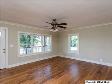 Living Room with gorgeous reclaimed oak hardwood floors, crown moulding & ceiling fan.