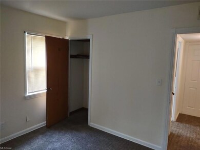 Unfurnished bedroom with multiple windows, a closet, and dark colored carpet