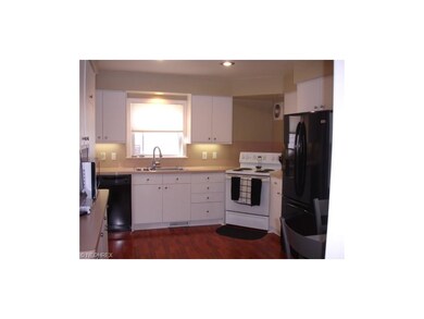 The spacious kitchen is neutral and features hardw