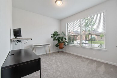 Secondary bedroom used as a study features carpet 