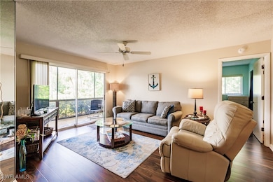 Living room with ceiling fan, dark hardwood / wood