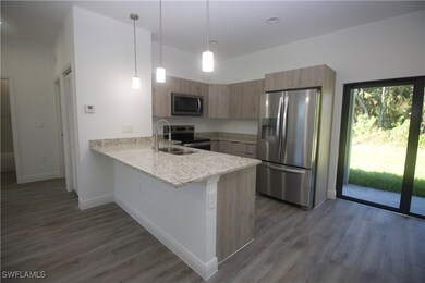 Kitchen featuring dark vinyl-type flooring, hangin
