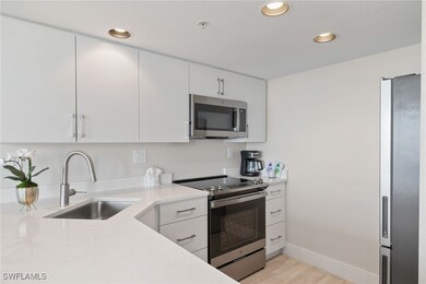 Kitchen featuring white cabinets, sink, light ston