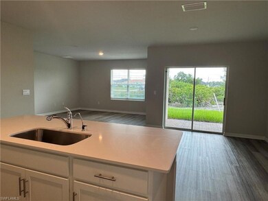Kitchen with wood finished floors, white cabinets, light countertops, open floor plan, and recessed lighting