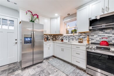 Kitchen with backsplash, light countertops, light