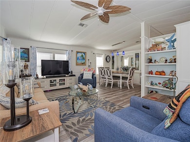 Living area featuring wood finished floors and a ceiling fan