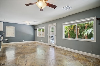 Spare room featuring baseboards and a ceiling fan