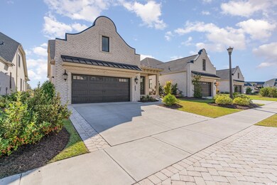 French country home featuring a front yard and a g
