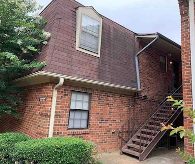 View of side of home with brick siding and roof with shingles