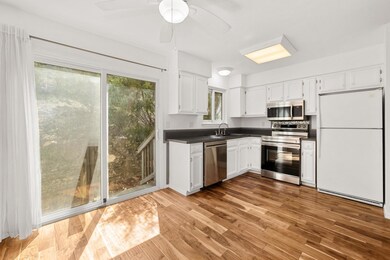 Kitchen featuring ceiling fan, dark countertops, 