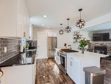 Stylish kitchen with granite or quartz countertops, stylish lighting, stainless appliances and a pantry closet.  Open flow to the living room.