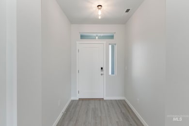 Entryway featuring baseboards and light wood finished floors