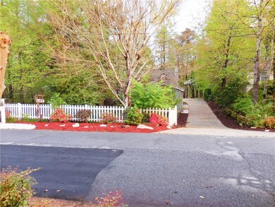 A pretty welcome to this cozy home neatly tucked into its wooded lot.