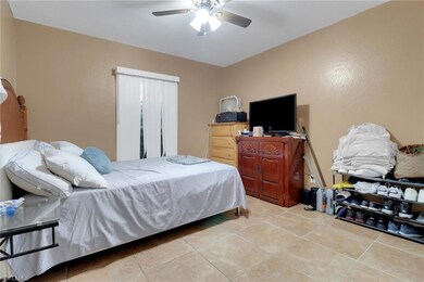 Tiled bedroom featuring a ceiling fan