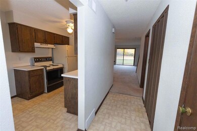 Corridor with a textured ceiling and light flooring