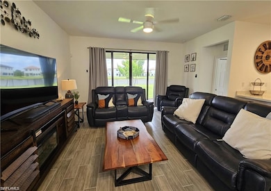 Living room with wood tiled floor, ceiling fan, an