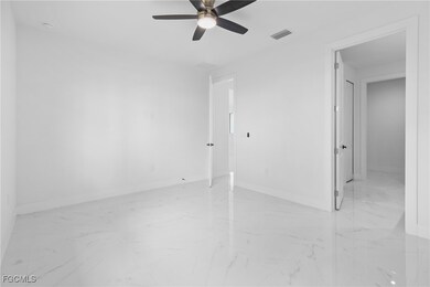 Unfurnished bedroom with light marble finish flooring and ceiling fan